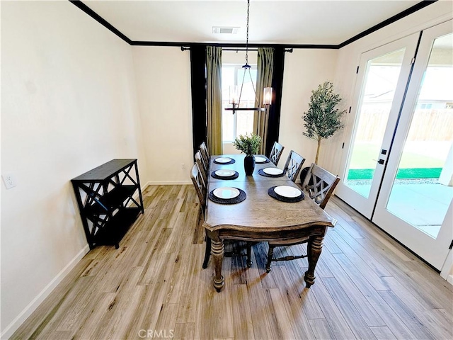 dining area featuring light wood-type flooring, french doors, and a healthy amount of sunlight