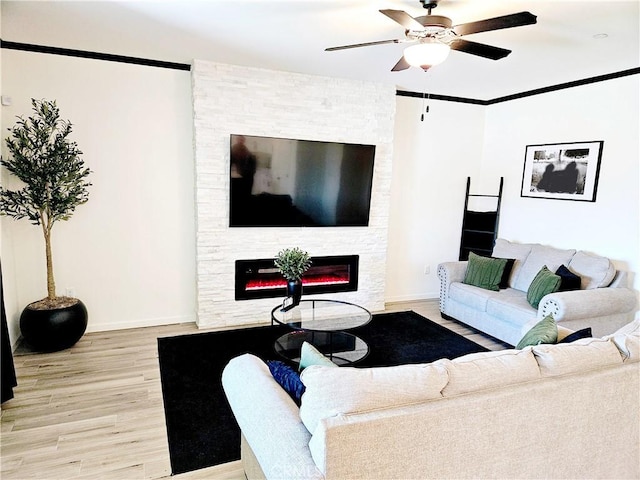 living room with a fireplace, light wood-type flooring, and ceiling fan