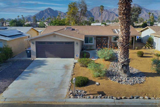 ranch-style house with a garage and a mountain view