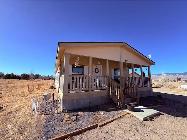 view of front of house with covered porch and a mountain view