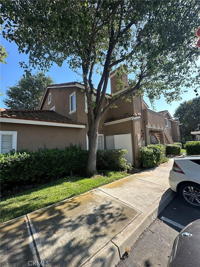 view of property with stucco siding and stairs