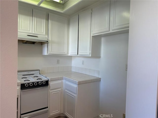 kitchen featuring white electric range, under cabinet range hood, tile counters, and white cabinetry