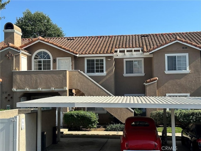 view of front facade with a tiled roof and stucco siding