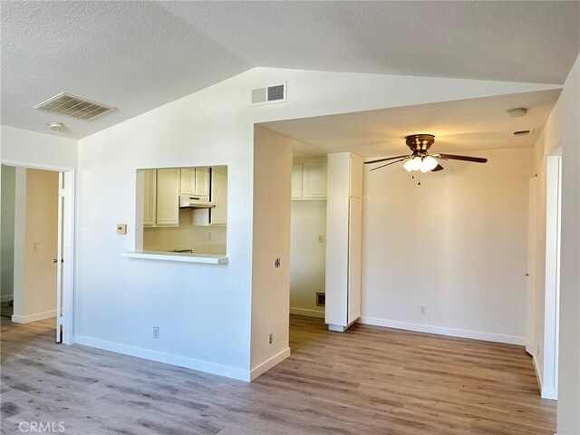 spare room featuring lofted ceiling, ceiling fan, and light hardwood / wood-style flooring