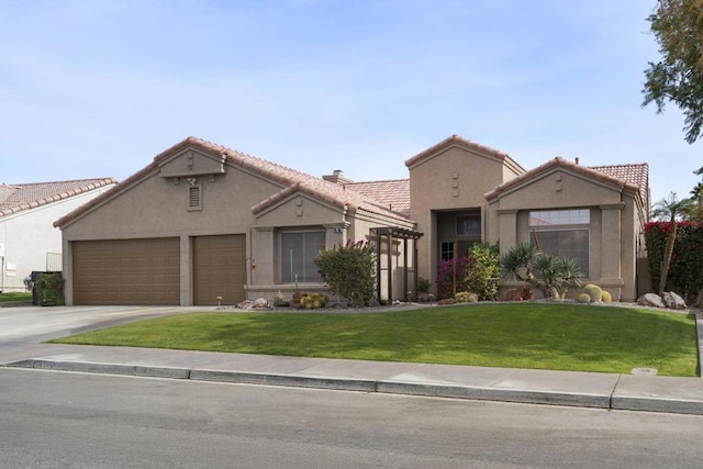 mediterranean / spanish house featuring a garage and a front yard