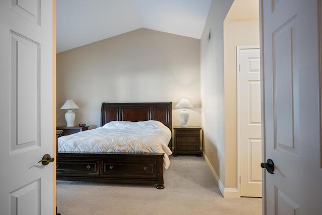 bedroom featuring light carpet and vaulted ceiling