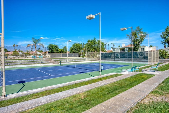 view of tennis court featuring a water view and basketball hoop