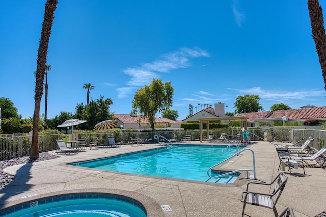 view of swimming pool with a patio area and a hot tub