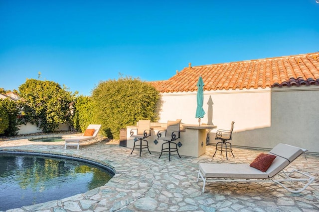 view of patio / terrace featuring a bar and a fenced in pool