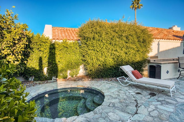 view of pool featuring a patio area and an in ground hot tub