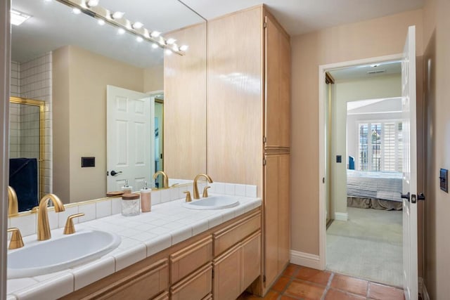 bathroom with tile patterned flooring, a shower with shower door, and vanity