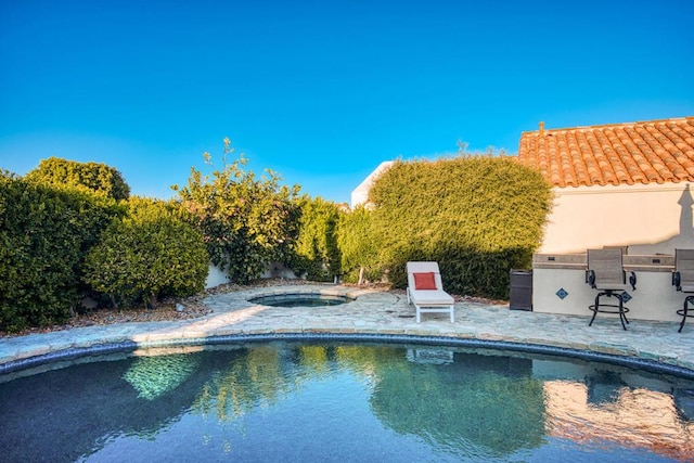 view of swimming pool featuring a patio and an in ground hot tub