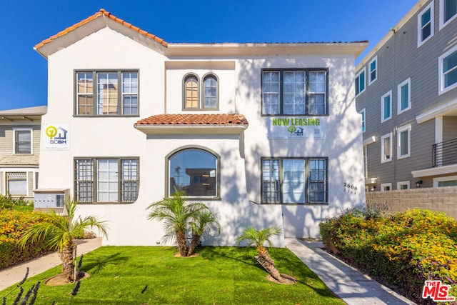 mediterranean / spanish home featuring a front lawn