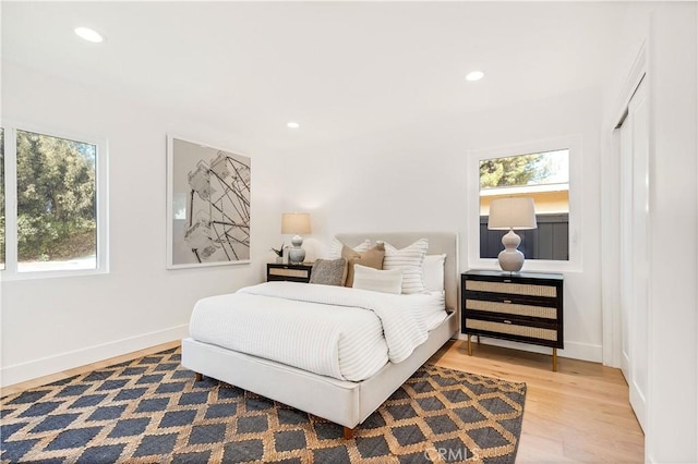 bedroom with hardwood / wood-style floors and multiple windows