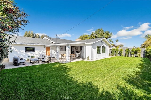 rear view of property with a lawn and a patio