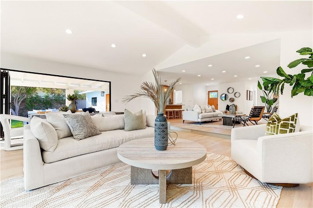 living room with light hardwood / wood-style floors and lofted ceiling with beams