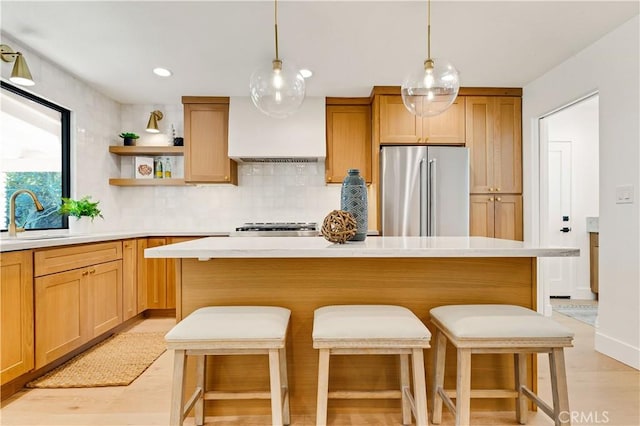 kitchen with sink, a center island, custom exhaust hood, decorative backsplash, and stainless steel fridge