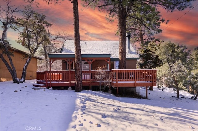 snow covered house featuring a deck