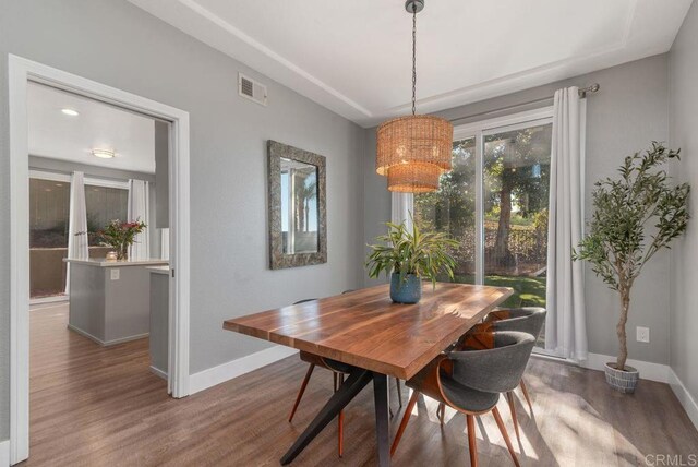 dining area featuring a chandelier and dark wood-type flooring