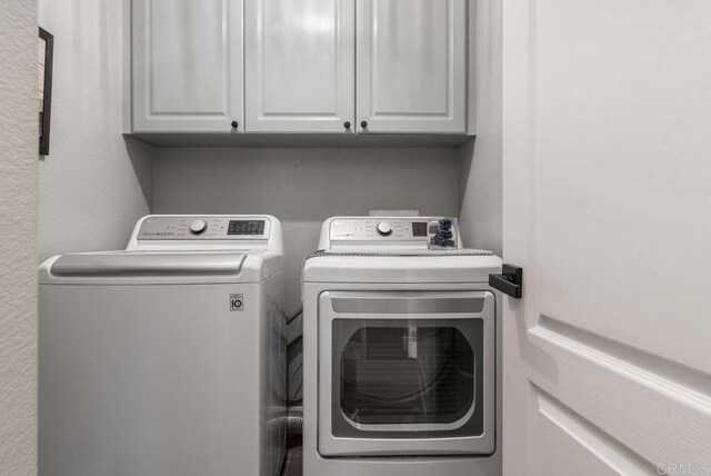 laundry room featuring cabinets and washing machine and clothes dryer