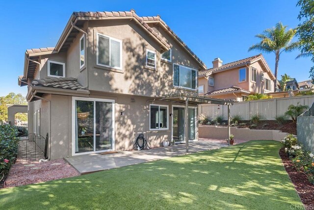 back of property featuring a patio, a lawn, and a pergola