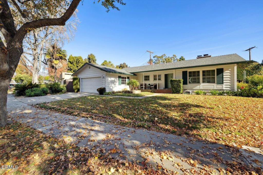 single story home featuring a garage, a front lawn, and a porch