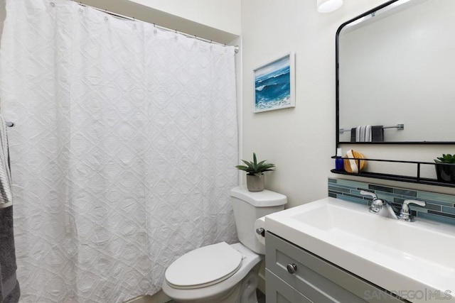 bathroom featuring toilet, backsplash, and vanity