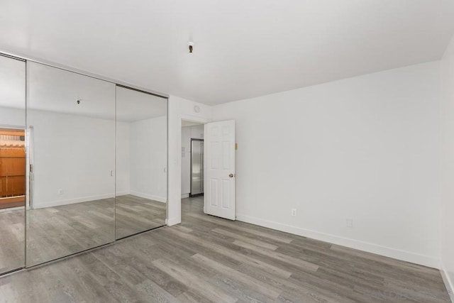 unfurnished bedroom featuring wood-type flooring and a closet