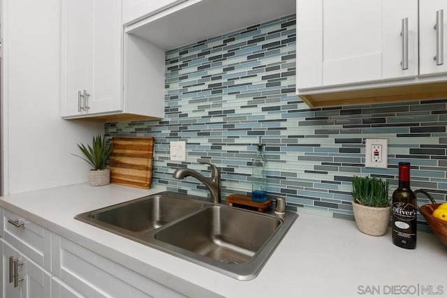 kitchen with white cabinets, tasteful backsplash, and sink