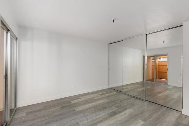 unfurnished bedroom featuring a closet and wood-type flooring