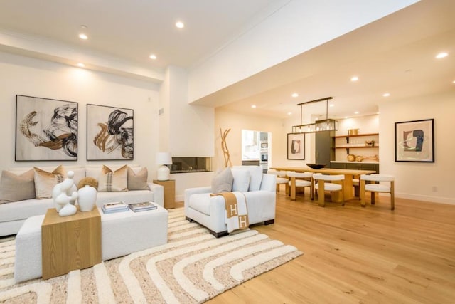 living room with ornamental molding and light hardwood / wood-style flooring