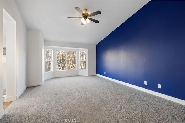 spare room featuring lofted ceiling, ceiling fan, and light colored carpet