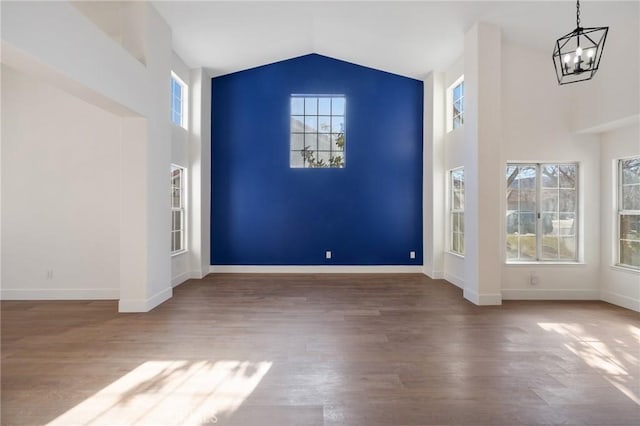 entrance foyer featuring wood-type flooring, an inviting chandelier, and vaulted ceiling