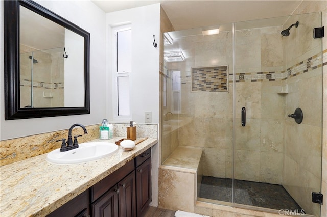 bathroom with a shower with shower door and vanity