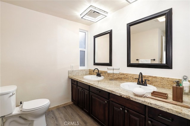 bathroom with toilet, vanity, and hardwood / wood-style floors