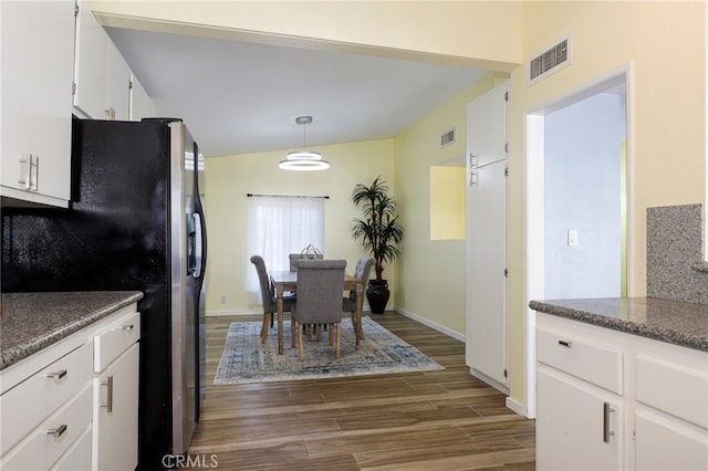 kitchen featuring dark hardwood / wood-style flooring, stainless steel fridge with ice dispenser, hanging light fixtures, and white cabinetry