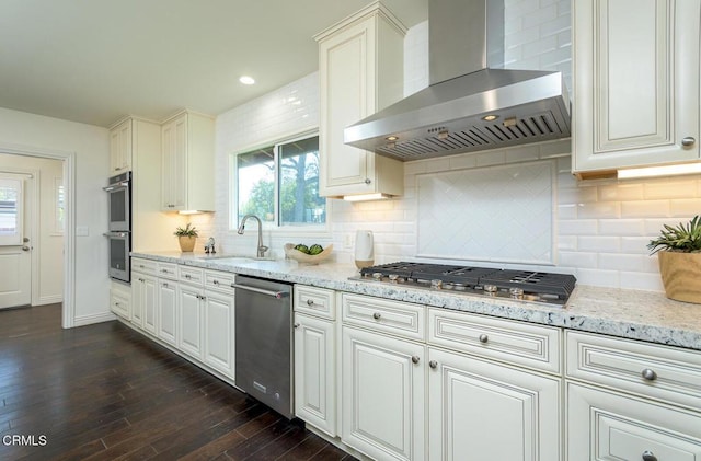 kitchen with exhaust hood, white cabinetry, appliances with stainless steel finishes, and sink