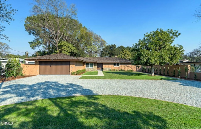 ranch-style home featuring a front lawn and a garage