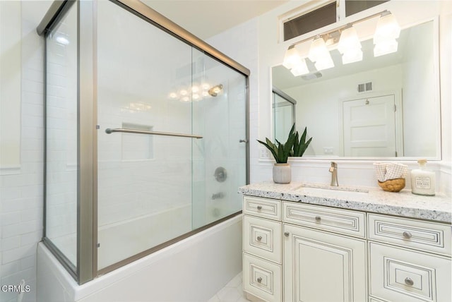 bathroom featuring shower / bath combination with glass door and vanity