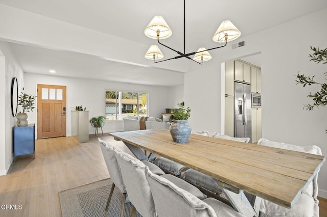 dining space featuring a notable chandelier and light hardwood / wood-style floors