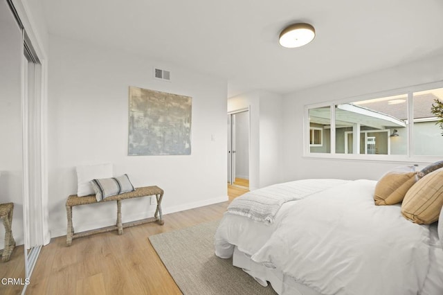 bedroom with light hardwood / wood-style floors and a closet