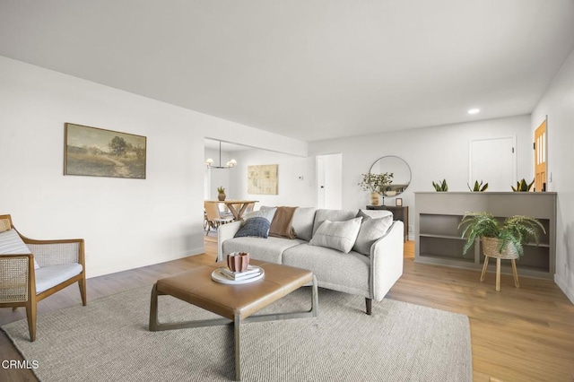 living room featuring an inviting chandelier and light hardwood / wood-style floors