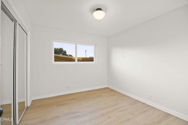 unfurnished bedroom featuring a closet and light hardwood / wood-style flooring