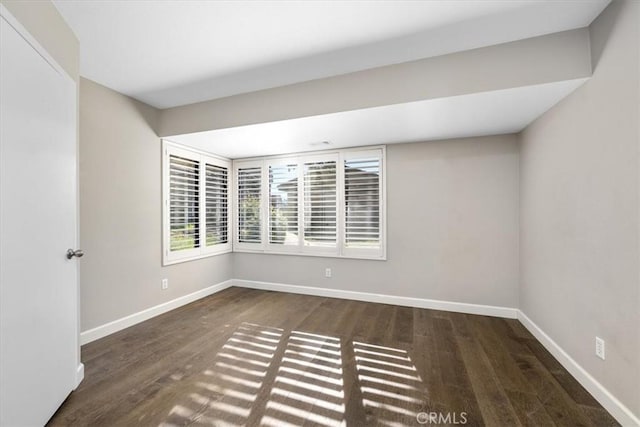 spare room with dark wood-type flooring