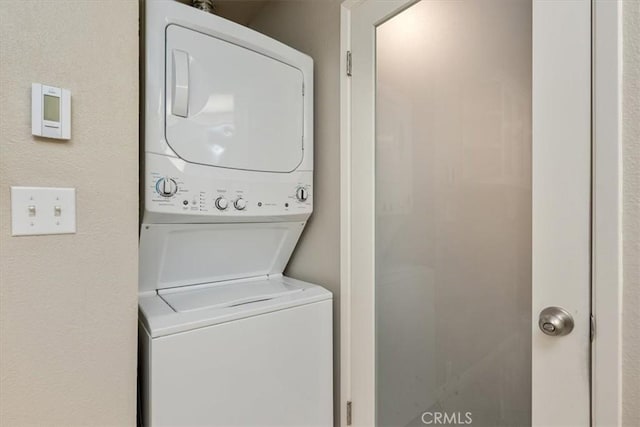 washroom featuring stacked washer / dryer