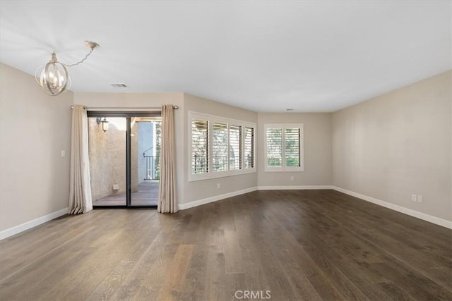 unfurnished room featuring hardwood / wood-style floors and an inviting chandelier