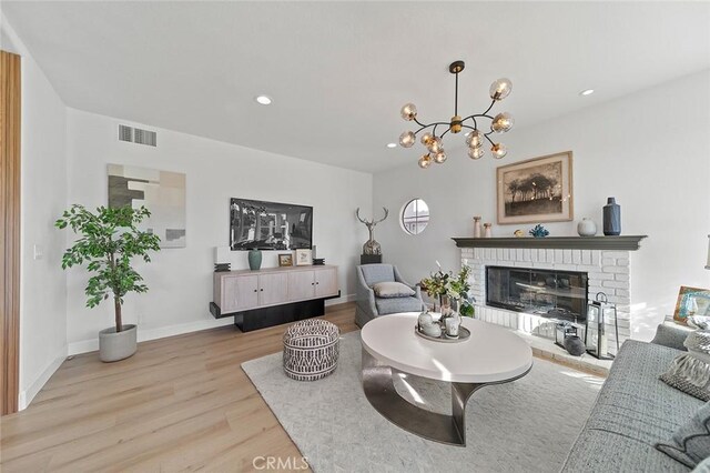 20 Flores, Lake Forest, CA 92610 - living room featuring light wood-type flooring, an inviting chandelier, and a fireplace