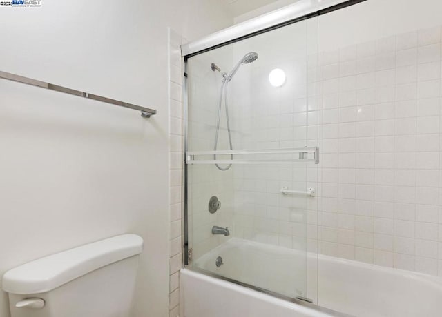 bathroom featuring enclosed tub / shower combo and toilet