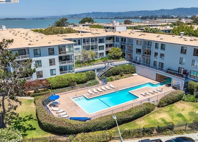 view of pool featuring a water view and a patio area