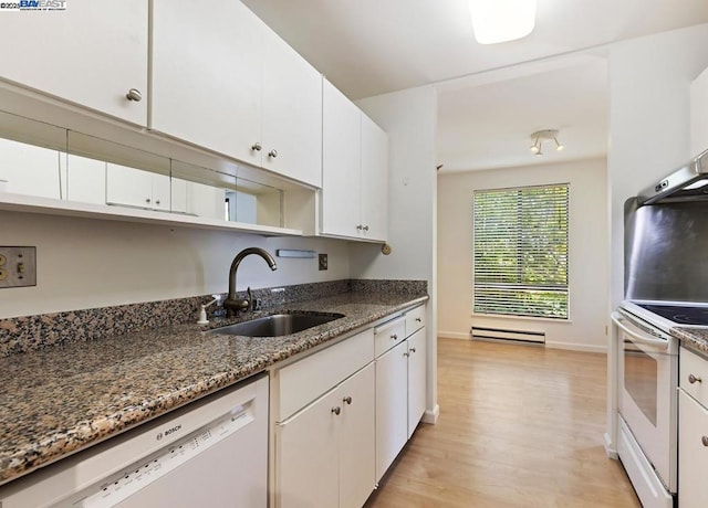 kitchen with white appliances, white cabinets, dark stone countertops, and sink